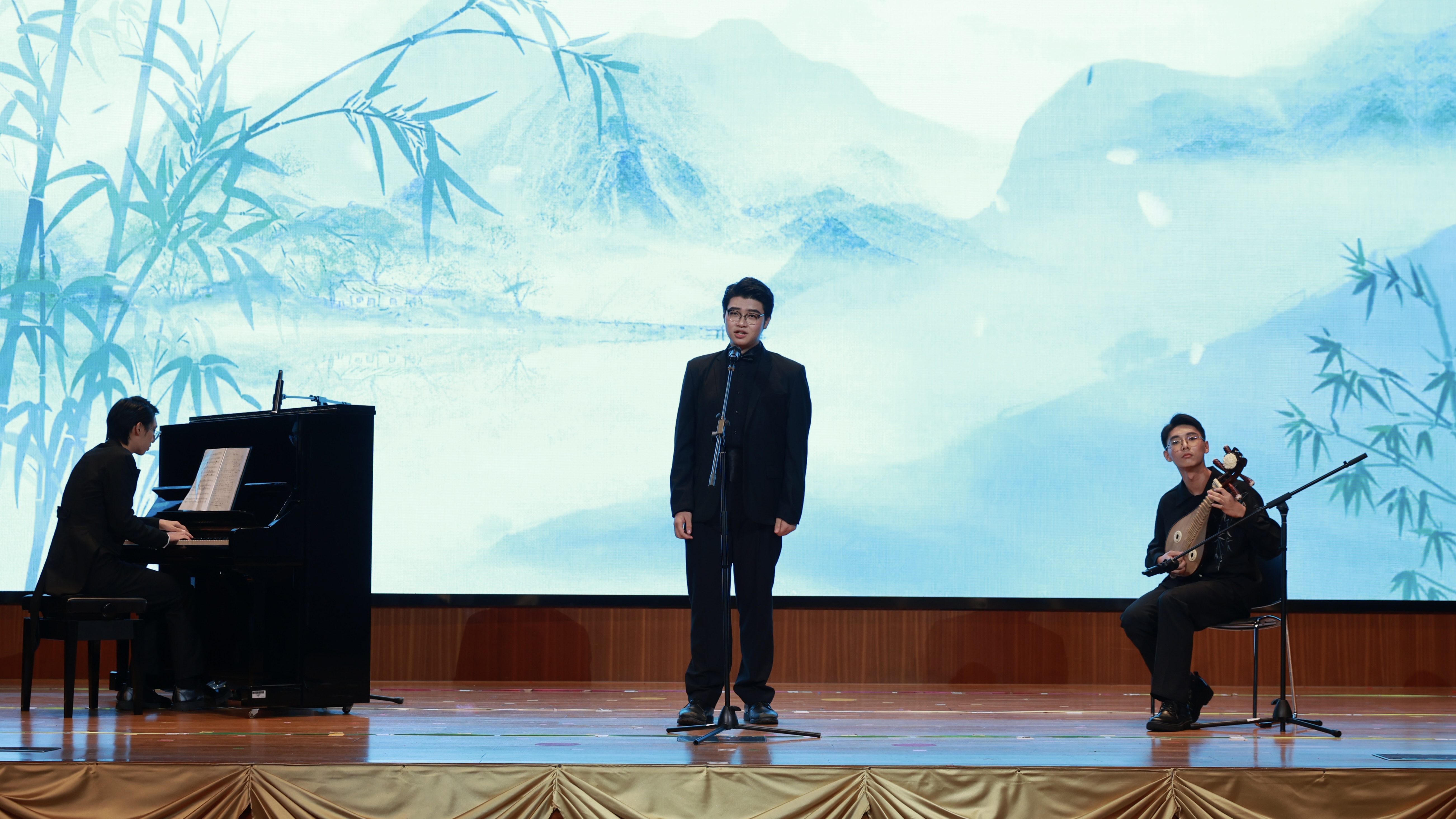 9中學部嚴近仁右任浩楊中劉樂賢左同學通過柳琴演唱和鋼琴伴奏演繹春土頌歌